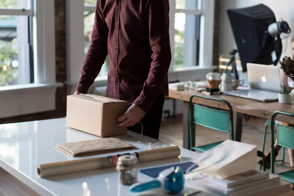 Person holding cardboard box on table