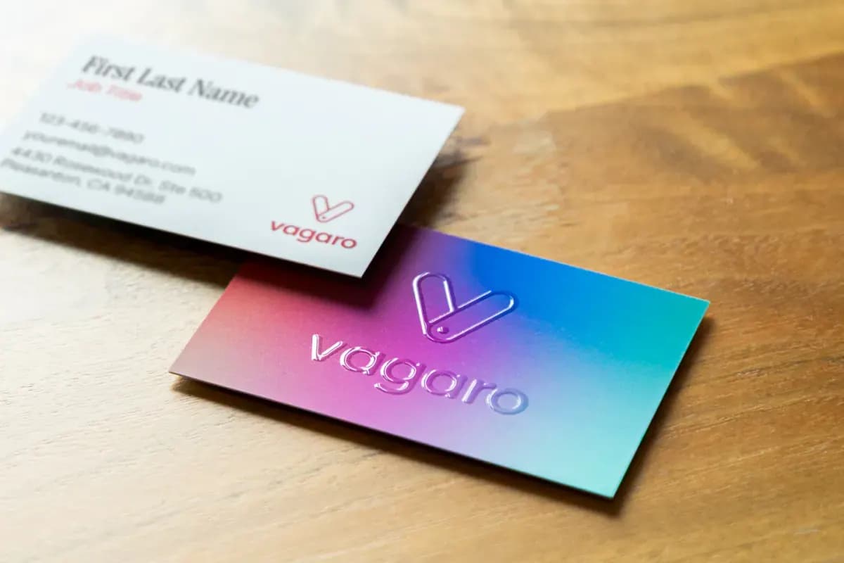 Two business cards on a wooden surface