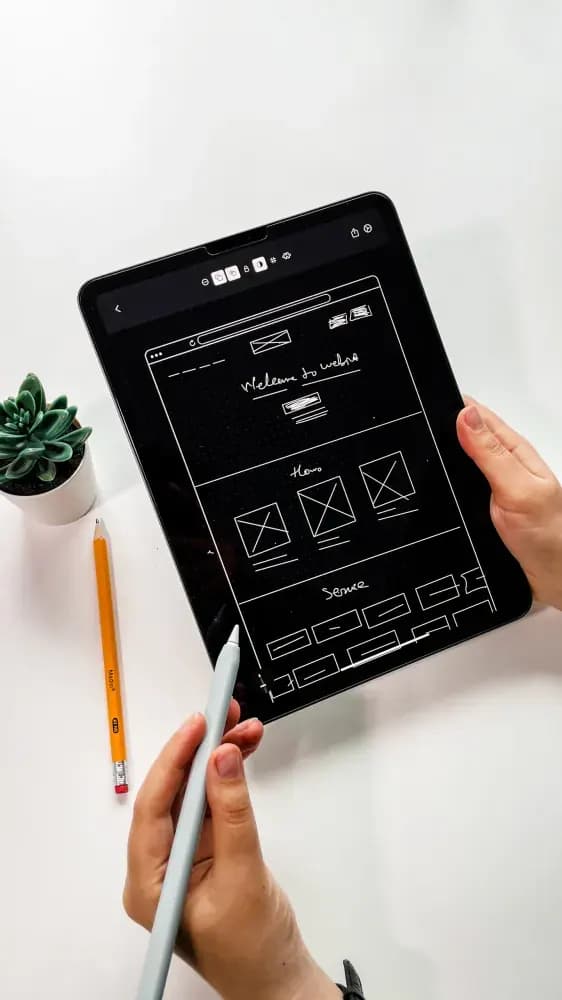 Person holding black ipad with green plant